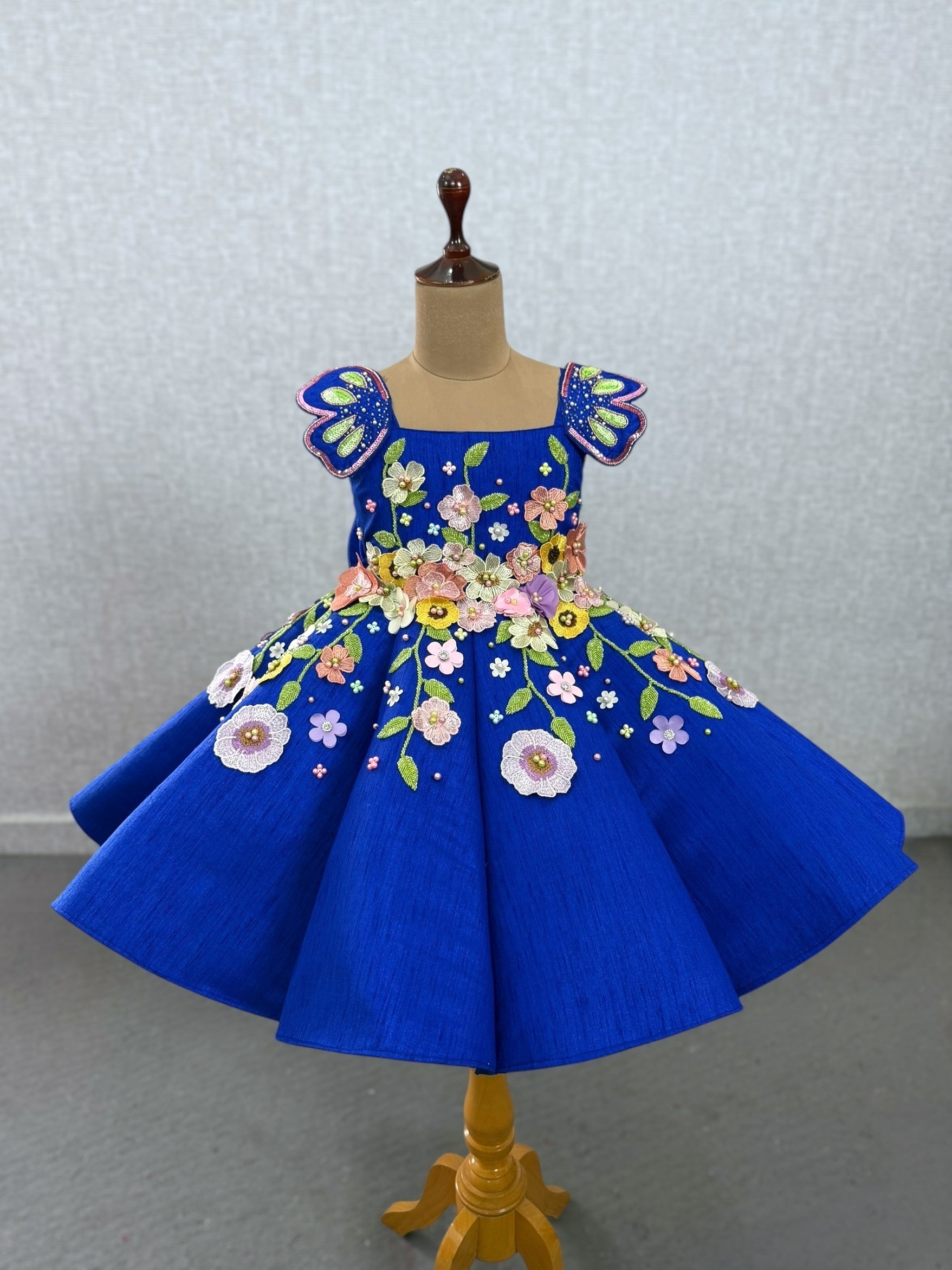 royal blue panel gown with heavy embroidered flowers and shoulder butterfly