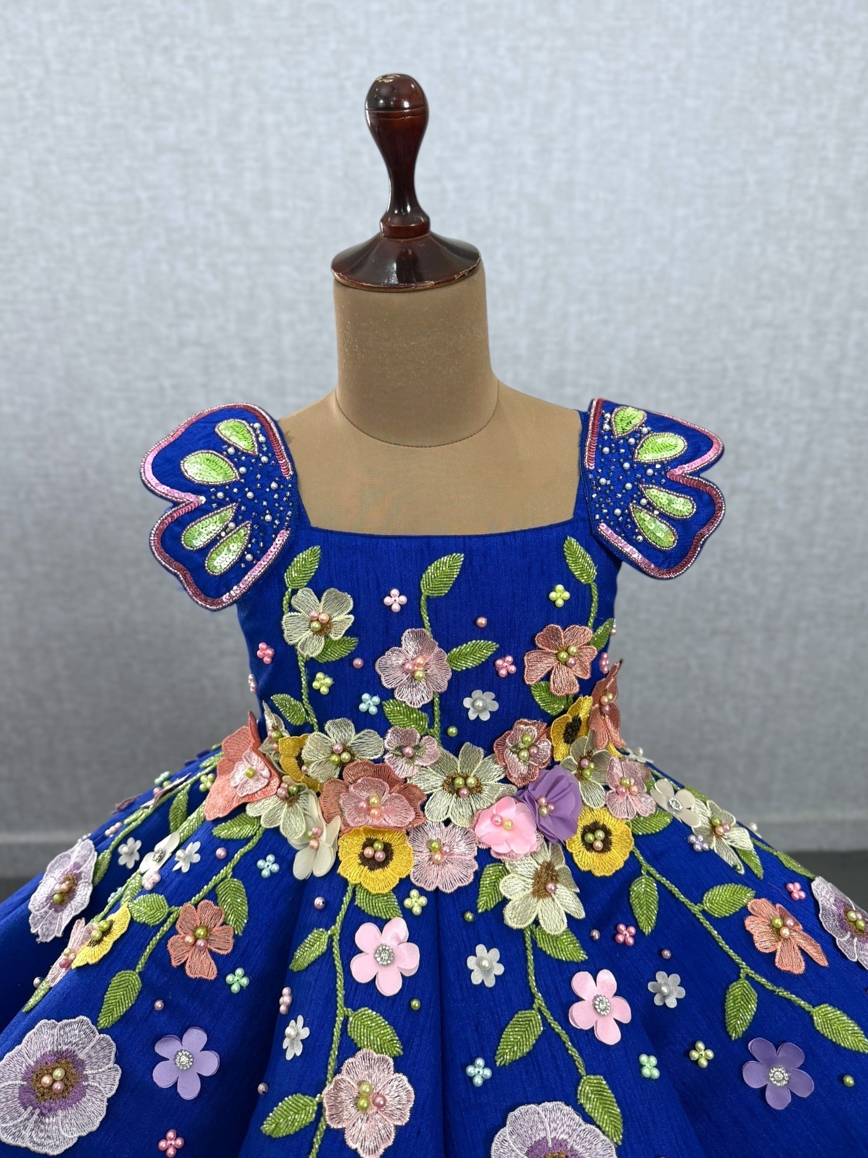 royal blue panel gown with heavy embroidered flowers and shoulder butterfly