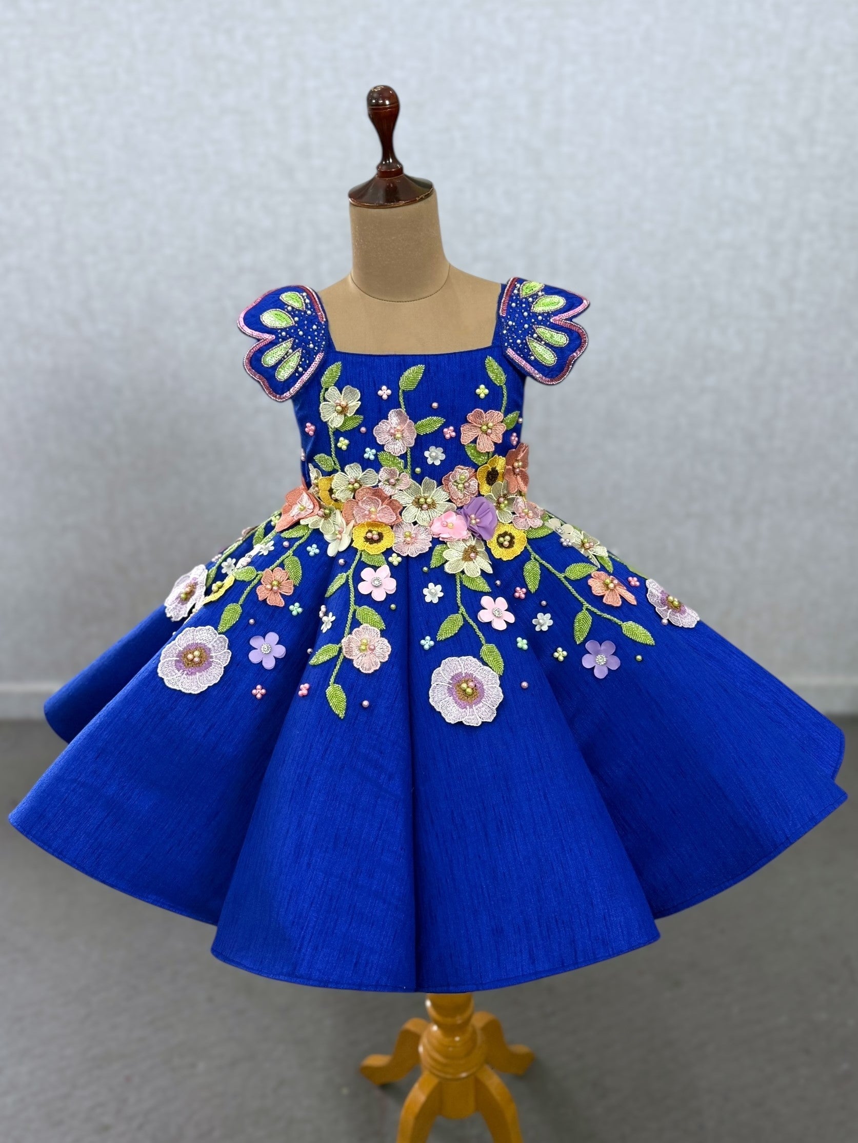 royal blue panel gown with heavy embroidered flowers and shoulder butterfly